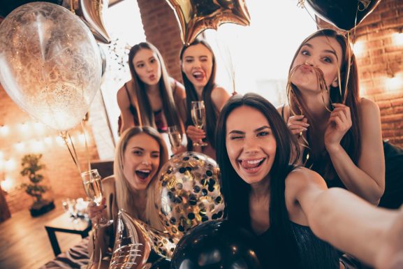 groupe de filles qui se prennent en photo avec un verre à la main