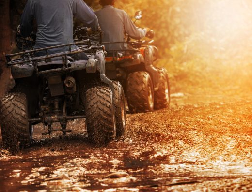 Deux quads roulant sur un chemin boueux lors d’une sortie tout-terrain en pleine nature.