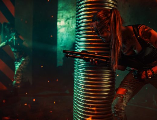 Joueuse équipée d’un pistolet laser se cachant derrière un obstacle lors d’une partie de laser game indoor.
