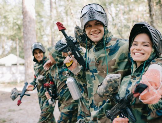 Groupe de jeunes joueurs en tenue camouflage participant à une partie de paintball en forêt
